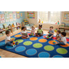 Children playing with toys on a colorful mat in a classroom setting. Color_Carnival_Dots_Rug