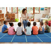 Teacher reading to a group of children in a classroom setting on the SensoryEdge Blue Sea Seating Grid Rug