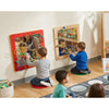 Children playing with educational wall toys in a classroom setting. Featuring the mirror and bead wall activity and a SensoryEdge seating rug.