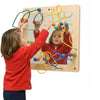 A child playing with a colorful educational wall toy.