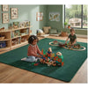Children playing with toys on a green rug in a room with bookshelves and a window.