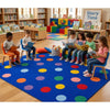 Children sitting on a colorful rug in a classroom setting, reading books.