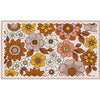 A rectangular area rug with a retro 1970s floral pattern featuring large stylized flowers in orange, yellow, pink, and white with brown leaves on a cream background, finished with a brown checkered border.