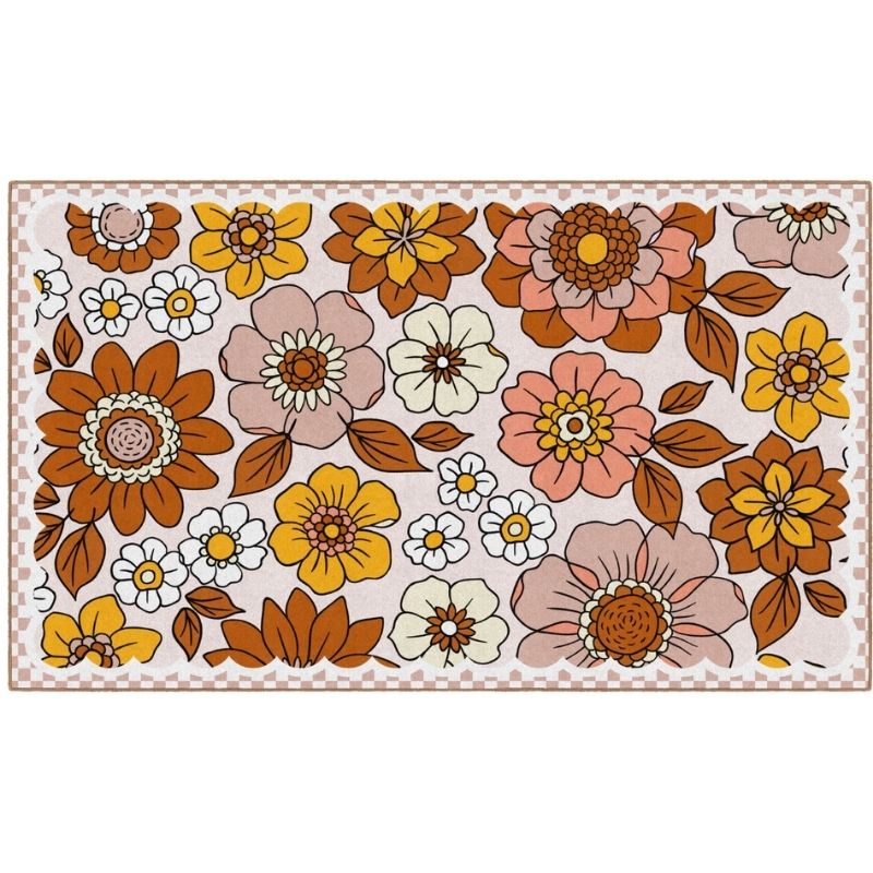 A rectangular area rug with a retro 1970s floral pattern featuring large stylized flowers in orange, yellow, pink, and white with brown leaves on a cream background, finished with a brown checkered border.