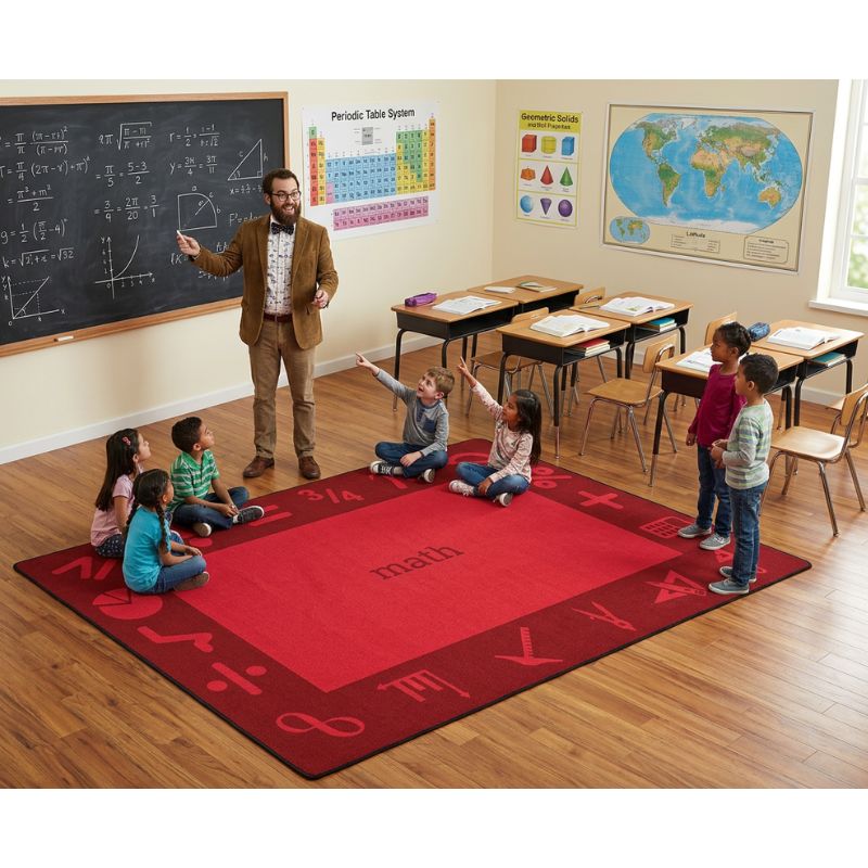 Teacher with students on a red math-themed rug in a classroom.