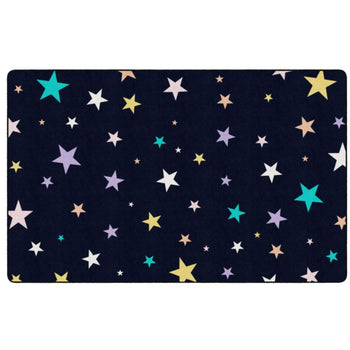 A rectangular area rug with a dark navy black background covered in a scattered pattern of stars in white, yellow, teal, and light purple, shown flat against a white background.