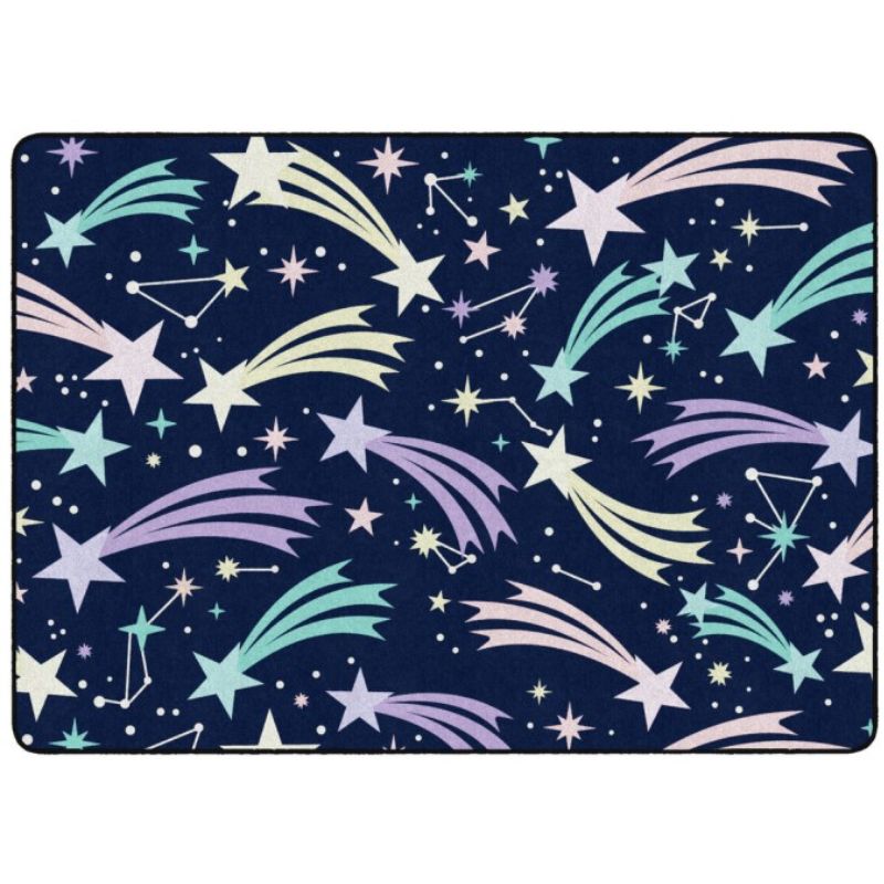 A rectangular area rug with a dark navy blue background, decorated with a repeating pattern of pastel-colored shooting stars, stars, and constellations.