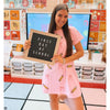 Teacher holding a 'First Day of School' sign ion a classroom rug