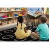Teacher reading a book to two children in a classroom setting on the circle_sampler_pastel_rug.