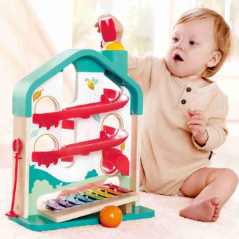 Child playing with a colorful toy structure on a light background