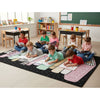 Children sitting on a colorful rug in a classroom setting. _stack_of_books_rug