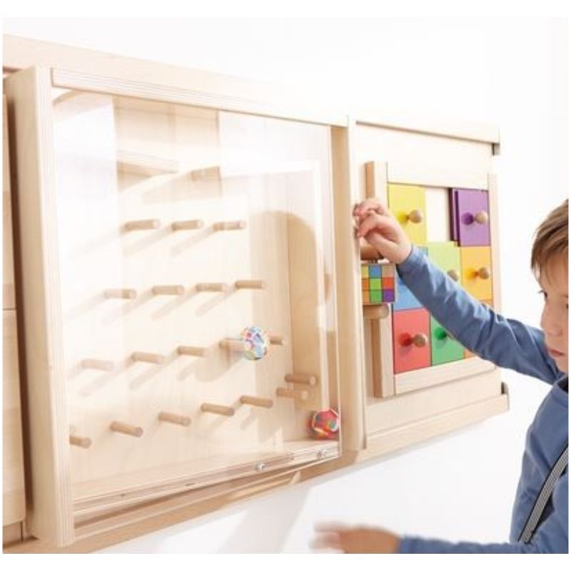 The Rubber Ball Plinko Sensory Wall Activity Toy has two rubber balls that bounce down behind the acrylic glass panel. Only nimble fingers can get them out through the side tunnel and back up to the top.